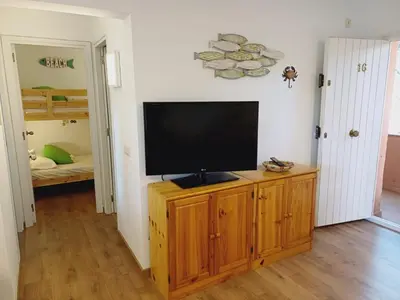 Una televisión o centro de entretenimiento en Apartamento con piscina y wifi cerca de la playa