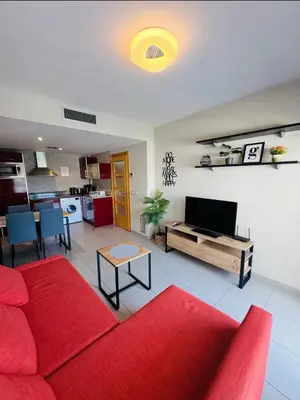 Una televisión o centro de entretenimiento en Hermoso piso en un paso de la Playa de Fenals con piscina