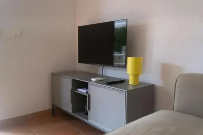 Una televisión o centro de entretenimiento en Parc Golfet - Apartamento para 3 con WiFi, AC y Piscina