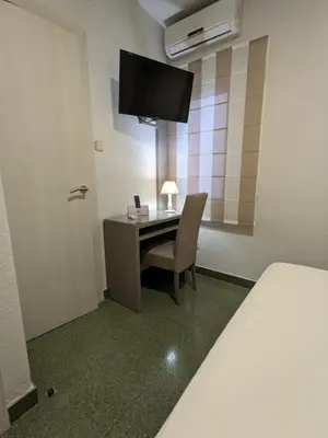 Una televisión o centro de entretenimiento en Hotel Capri