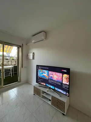Una televisión o centro de entretenimiento en Apartamento con Terraza,Piscina,Playa y Aire acondicionado