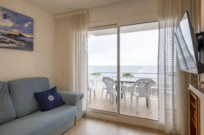 Una televisión o centro de entretenimiento en Apartamento con vistas al mar y piscina en Platja d'Aro