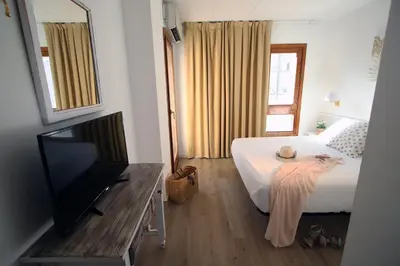 Una televisión o centro de entretenimiento en Hotel Mireia