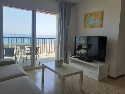 Una televisión o centro de entretenimiento en Suitur apartamento primera linea mar vistas playa