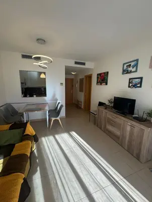 Una televisión o centro de entretenimiento en Precioso piso cerca de playa Fenals con 2 piscinas y terraza