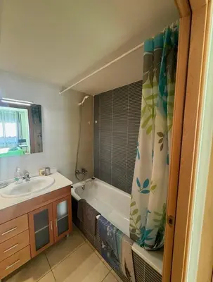 Un baño de Precioso piso cerca de playa Fenals con 2 piscinas y terraza