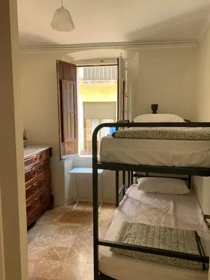 Cama o camas de una habitación en NOTARIA-Apartamento y Estudio en casco antiguo, al lado de playa, Rambla y Monasterio, con acceso a terraza ajardinada
