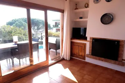 Una televisión o centro de entretenimiento en Apartamento con piscina L' Áncora