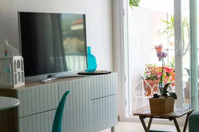 Una televisión o centro de entretenimiento en Alegre apto con piscina, a 300m de la playa.